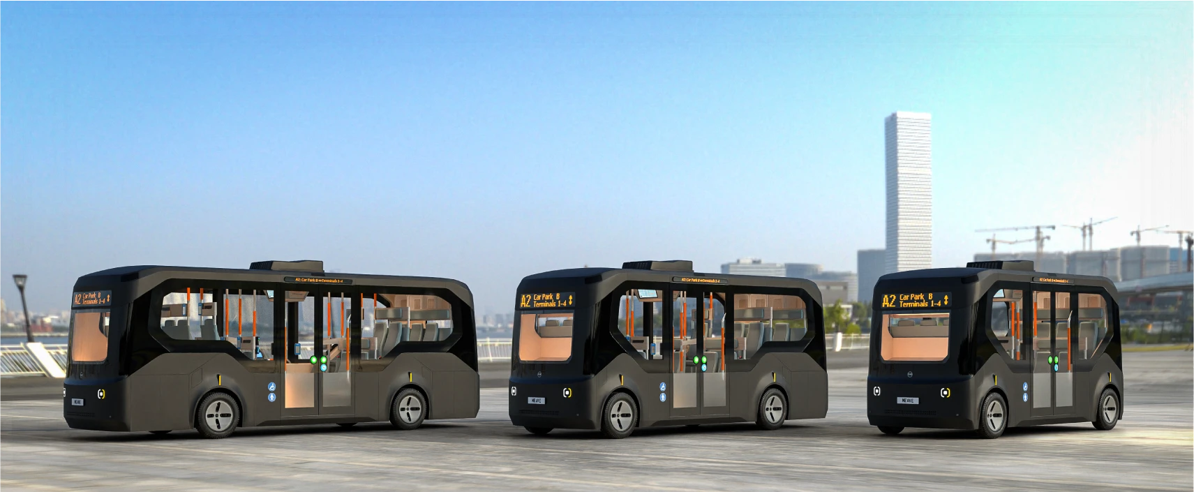 Three autonomous shuttle buses on a city street with the skyline behind them